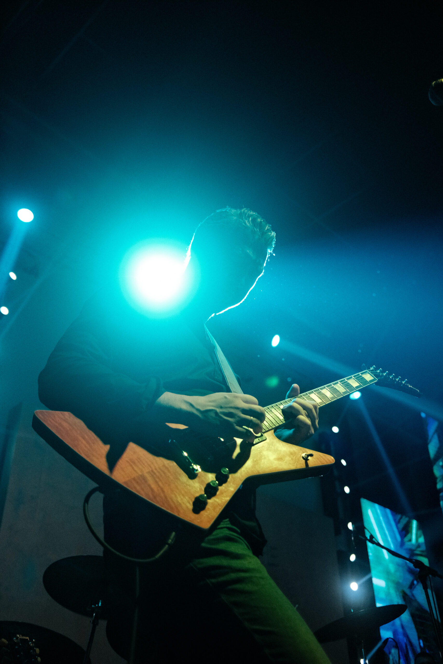 Músico tocando guitarra eléctrica con intensidad en el escenario